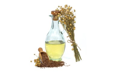 Cam sürahide keten tohumu yağı ve beyaz arka planda izole edilmiş keten bitkilerinin yanında tahta kepçe içinde keten tohumu. Linum usitatissimum (Yaygın Flax)