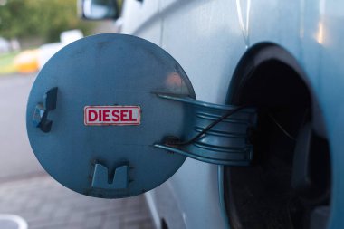 Yakıt deposunun kapağına dizel için kırmızı tabelası olan bir araç.