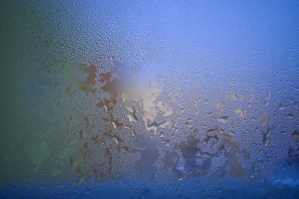 Water droplets or condensation on the outside of a cold windows in a close up full frame background texture