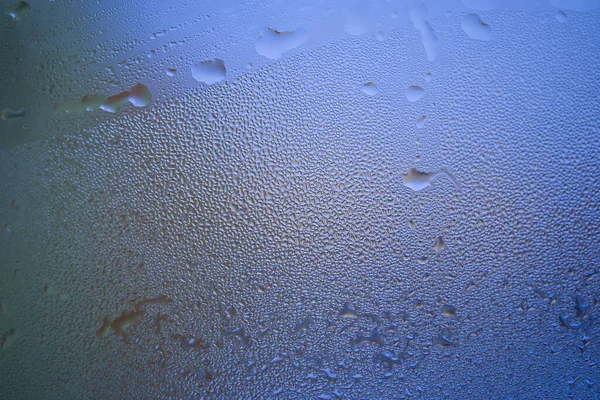Water droplets or condensation on the outside of a cold windows in a close up full frame background texture