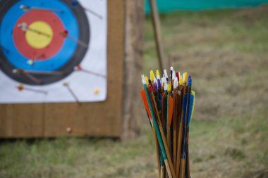 Colorful archery arrows in close up and unfocused target board in background