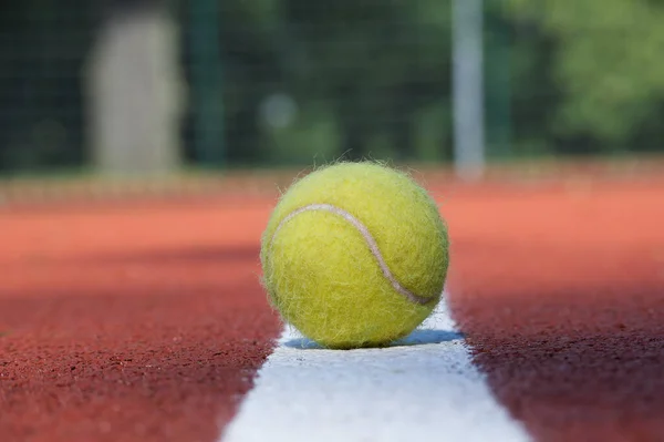 stock image Tennis scene with white line and ball on hard court surface in low angle view