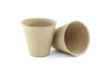 Sebze otları için biyo-çözünebilir gübre saksıları beyaz arka planda saklanmış çiçekler. Sebze bitkileri için gübrelenebilir çaydanlık. Çiçekler.