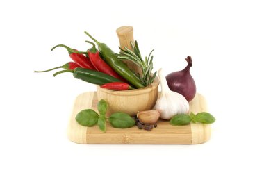 Baharatlar, otlar ve lezzet temalı. Ahşap havan, kırmızı soğan, karabiber, fesleğen filizi ve beyaz arka planda izole edilmiş sarımsak soğanı ile hayat devam ediyor.