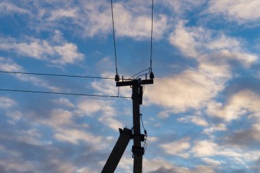 Yukarıdaki elektrik hattı ve direği olan bulutlu bir gökyüzü. Kamu hizmeti bir elektrik kaynağıdır ve birden fazla elektrik hattına bağlıdır.