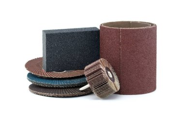 Açı öğütücüler için flap diskler, aşındırıcı bez kaplama tekerlekler ve matkap ve zımpara kağıdında kullanmak için fırça tekerlekleri beyaz arkaplanda izole edilmiş yakın plan görüntüde.