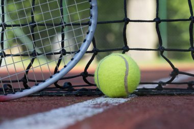 Beyaz çizgiye yakın sarı tenis topu ve siyah ağ, düşük açılı tenis sahnesi
