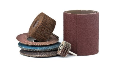 Açı öğütücüler için flap diskler, aşındırıcı bez kaplama tekerlekler ve matkap ve zımpara kağıdında kullanmak için fırça tekerlekleri beyaz arkaplanda izole edilmiş yakın plan görüntüde.