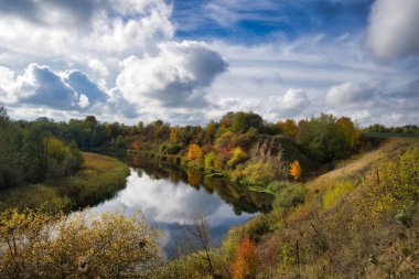 Sonbahar mevsimi, ağaçların yaprakları üzerinde çeşitli turuncu ve sarı tonlarda ağaçlar ve çalılarla çevrili bir su kütlesiyle gelir. Sakin ve yansıtıcı su çevresi