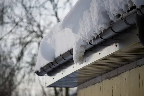 Заснеженная Канава Значительной Степени Заполнена Снегом Приближаясь Краю Крыши Стоковое Изображение