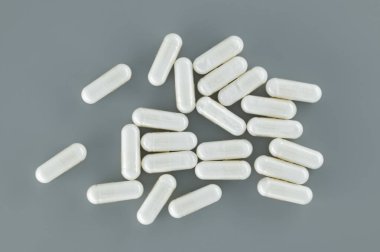 Gri bir yüzeye yayılmış çok sayıda beyaz hap. Ücretsiz fotokopi alanı olan asgari tıbbi ve ilaç konsepti