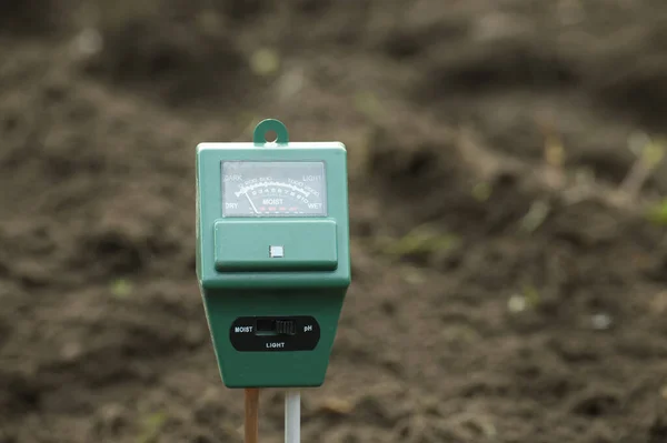 stock image Humidity meter features three sensors and a small screen that displays words 'DARK', 'LIGHT', 'DRY', 'MOIST', and 'ph'