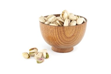 Tahta kâse, beyaz bir yüzeye dökülmüş fıstıkla dolu.