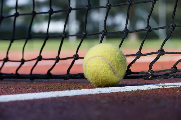 Tennis ball in the net. Ball hitting the tennis net, tennis scene with black net and yellow ball
