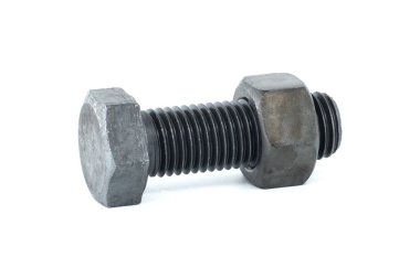 Siyah metal altıgen cıvata ve fındık beyaz arka planda izole edilmiş yakın planda görünüyor.