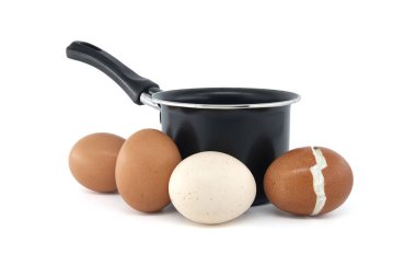 Farklı renklerde yumurtaların toplandığı siyah tencere, kaynama sırasında bir yumurta çatlamış, beyaz arka planda izole edilmiş.