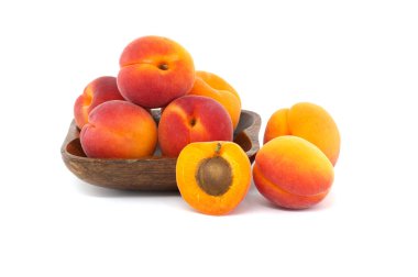 Group of fresh whole apricots and one cut in half to reveal its interior, isolated on a white background clipart