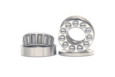 Single row tapered roller bearings and thrust ball bearings isolated on white background. Spare parts for machinery and automotive industry clipart