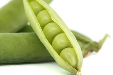 Beyaz arka planda bir kabuktaki taze taze bezelyelerin yakın çekimi. Taze ürünler, bahçıvanlık ve sağlıklı beslenmeyle ilgili kavramlar için mükemmel..