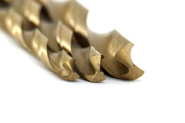 Sanayi, inşaat ve DIY projelerinde kullanılan keskin hassas araçları vurgulayarak, beyaz arkaplandaki metal matkap parçalarının görüntüsünü kapat.