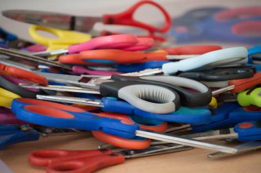 A diverse collection of colorful scissors stacked together, commonly used in artistic workspaces or classrooms to create various craft projects. clipart