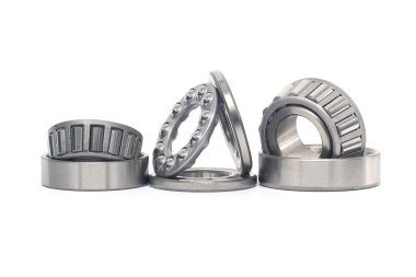 Tek sıra, beyaz arka planda izole edilmiş rulman ve itme bilyelerini inceltti. Makine ve otomotiv endüstrisi için yedek parça