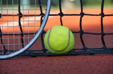 Tenis topu ve raketi kil sahada yaklaş. Spor, spor ve tenisle ilgili konular için ideal.