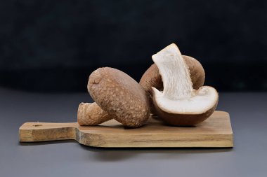 Kesme tahtasındaki taze shiitake mantarları ön planda, sağlıklı gıda ve farmakolojik özelliklerde, Lentinula edodes