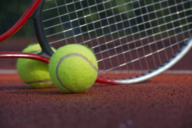 Tenis topu ve raketi kil sahada yaklaş. Spor, spor ve tenisle ilgili konular için ideal.