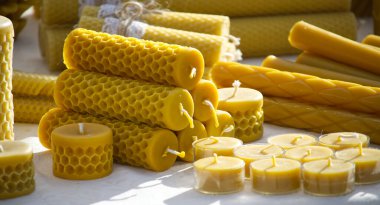 A collection of handmade beeswax candles in diverse forms, showcasing the intricate honeycomb texture and vibrant yellow hue, perfect for sustainable home decor and ambient lighting. clipart