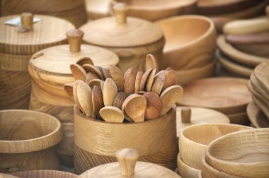 Bir pazarda sergilenen el yapımı ahşap kaşıklar ve kâselerden oluşan bir karışım, doğal zarafet ve kırsal işçiliği vurguluyor. Çevre dostu yaşam ve sürdürülebilir mutfak çözümleri için mükemmel..
