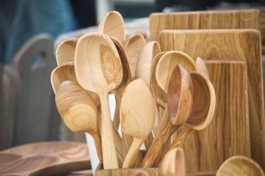 Bir pazarda sergilenen el yapımı ahşap kaşıklar ve kâselerden oluşan bir karışım, doğal zarafet ve kırsal işçiliği vurguluyor. Çevre dostu yaşam ve sürdürülebilir mutfak çözümleri için mükemmel..