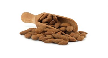 Taze bademlerle dolu ahşap bir kepçe temiz beyaz bir yüzeye dökülüyor ve besleyici fındıkları gösteriyor. Sağlık, diyet ve doğal gıdalar ile ilgili kavramlar için mükemmel.