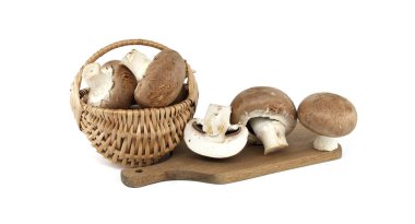 Hasır bir sepetten dökülen taze kremini mantarlar ahşap bir kesme tahtasına dökülüyor, bütün ve dilimlenmiş çeşitleri sergiliyorlar. Mutfak, organik gıda ve mutfak vitrinleri için ideal..