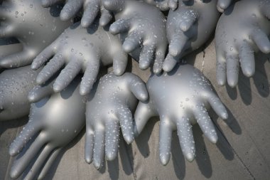 Su damlacıklarıyla kaplı şişirilmiş lastik eldiven koleksiyonu soyut ve sanatsal bir tasarım oluşturur. Görüntü, yaratıcılığı, benzersizliği ve dokusunu karmaşık düzeniyle ve yansıtıcı yüzeyleriyle iletir..