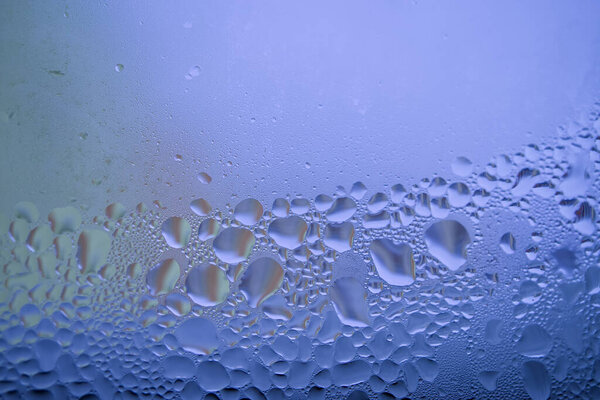 Water droplets or condensation on the outside of a cold window in a close up full frame background texture