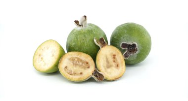 Dilimlenmiş yarımlarla sergilenen canlı yeşil feijoa meyveleri, sulu iç kısımları ortaya çıkarıyor. Tazelik, organik üretim ve sağlıklı yemek kavramları için mükemmel. Temiz beyaz arkaplana karşı ayarla