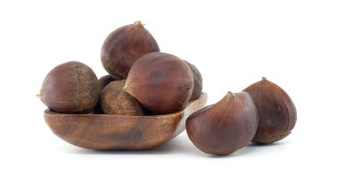 Kırsal ahşap bir kasede taze kestane gösterisi. Sonbahar tarifleri ve mevsimlik dekorlar için mükemmel. Sonbaharın özünü bu davetkar görüntüyle yakala.