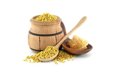 İçinde arı poleni, bir kaşık ve doğal ve sağlıklı bir estetik için bal peteği olan bir kâse bulunan ahşap bir fıçı..