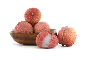 Lychee meyveleri ahşap bir kasede sergileniyor, canlı pembe derilerini ve beyaz bir zemine yerleştirilmiş sulu beyaz etlerini sergiliyorlar. Egzotik tropikal meyvenin ve lezzetli cazibesinin bir temsili.