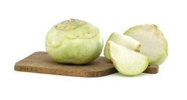 Taze kohlrabi sebzesi bir bütün olarak betimlenmiş ve beyaz arka planlı ahşap bir kesme tahtasına dilimlenmiş..