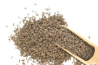 Caraway seeds are spilling from a wooden scoop onto a clean white background, creating a visually appealing arrangement with potential use in food, culinary, or spice related contexts clipart