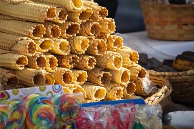 Gofret ruloları, lolipoplar ve çeşitli şekerlemeler içeren renkli bir şeker düzenleme, tatlı bir ikram için hazır..