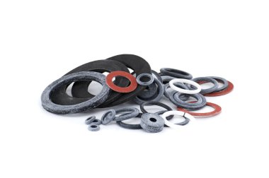 Çeşitli boylarda ve renkli endüstriyel contalardan oluşan bir koleksiyon stüdyo çekimi için beyaz bir arka planda düzenlenir..