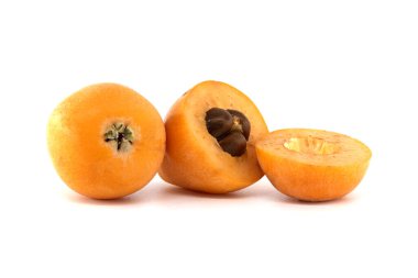 Eriobotrya japonica, tohumları ortaya çıkarmak için tek bir kesikle beyaz bir zemin üzerinde taze loquats yakın çekim.
