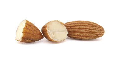 Parlak beyaz bir arka planda üç badem yakın çekim, gösterişli detaylar. Bir bütündür, iki tanesi kırılarak açılır ve içini gösterir..