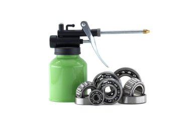 Farklı boyutlarda bir bilye koleksiyonu, temiz, beyaz arka planda yeşil bir yağ tenekesinin yanında..