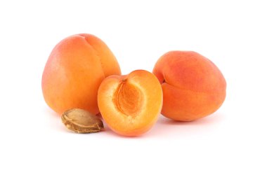 Yakın plan taze kayısılar ikiye bölünmüş ve tohumları ortaya çıkmış, beyaz üzerine izole edilmiş..