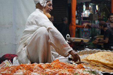 7 Nisan 2023, Zakaria Caddesi, Kolkata, Batı Bengal, Hindistan. Mağaza sahibi, Nakhoda Mescid Kolkata yakınlarındaki bayram sırasında Zakaria Caddesi 'nde Halwa ve Paratha' yı sat.