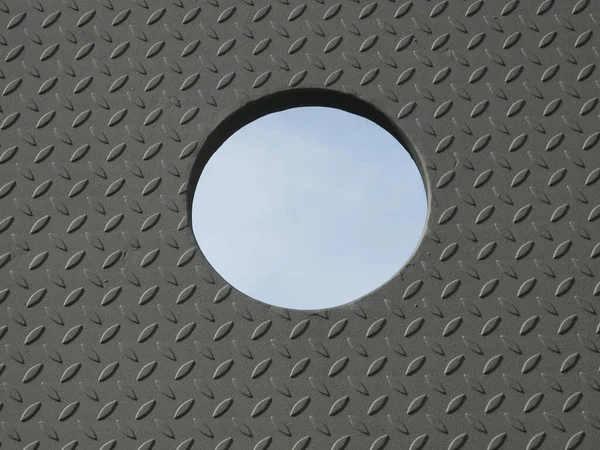 a detail of a diamond plate door with a hole in the middle